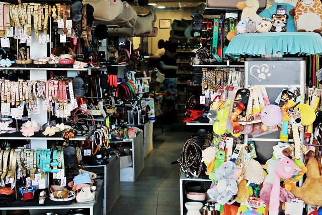 Pasillo central de la tienda, con la pared de collares a un lado y la de juguetes al otro